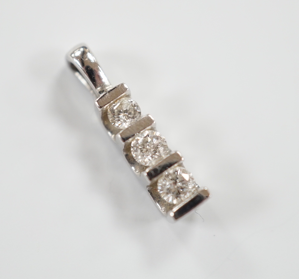 A modern 750 white metal and three stone diamond set pendant, 15mm, gross weight 0.9 grams.